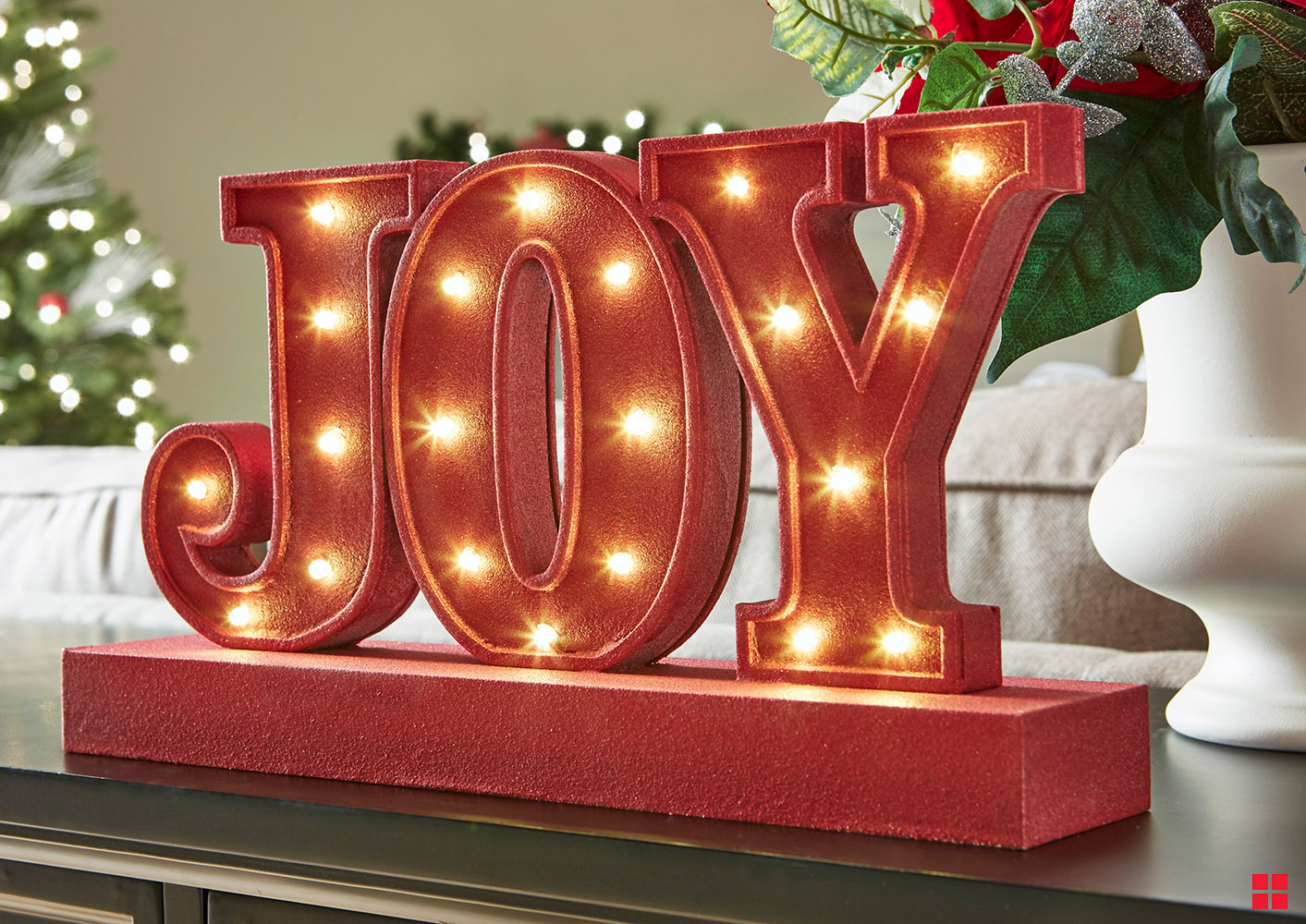 Joy sign spray painted with red glitter.