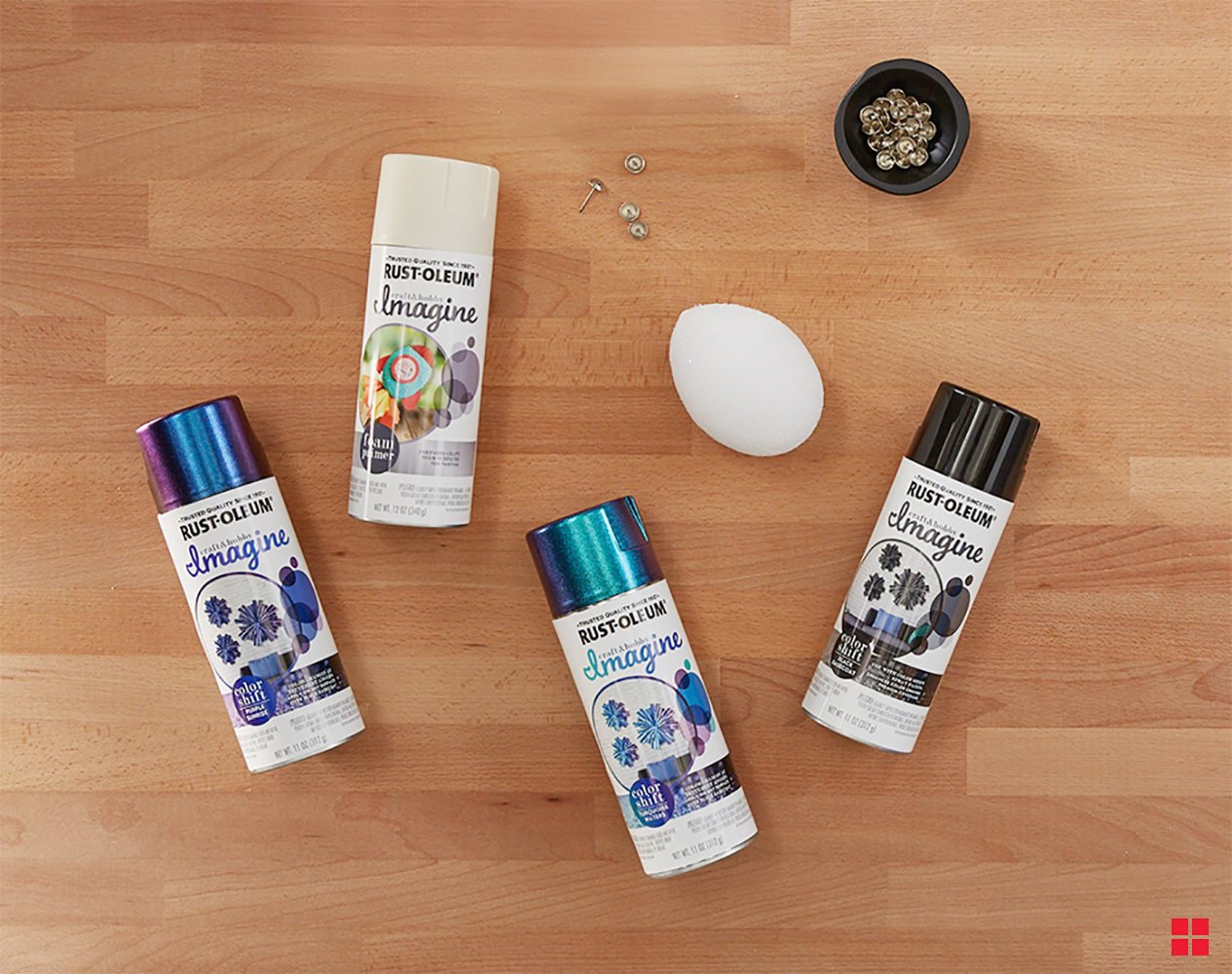 Four cans of Rust-Oleum spray paint, foam egg and thumbtacks.