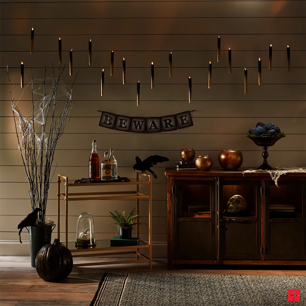 Painted candlesticks hanging above furniture and Halloween decorations.