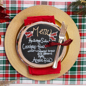 A chalkboard menu on top of a holiday place setting.