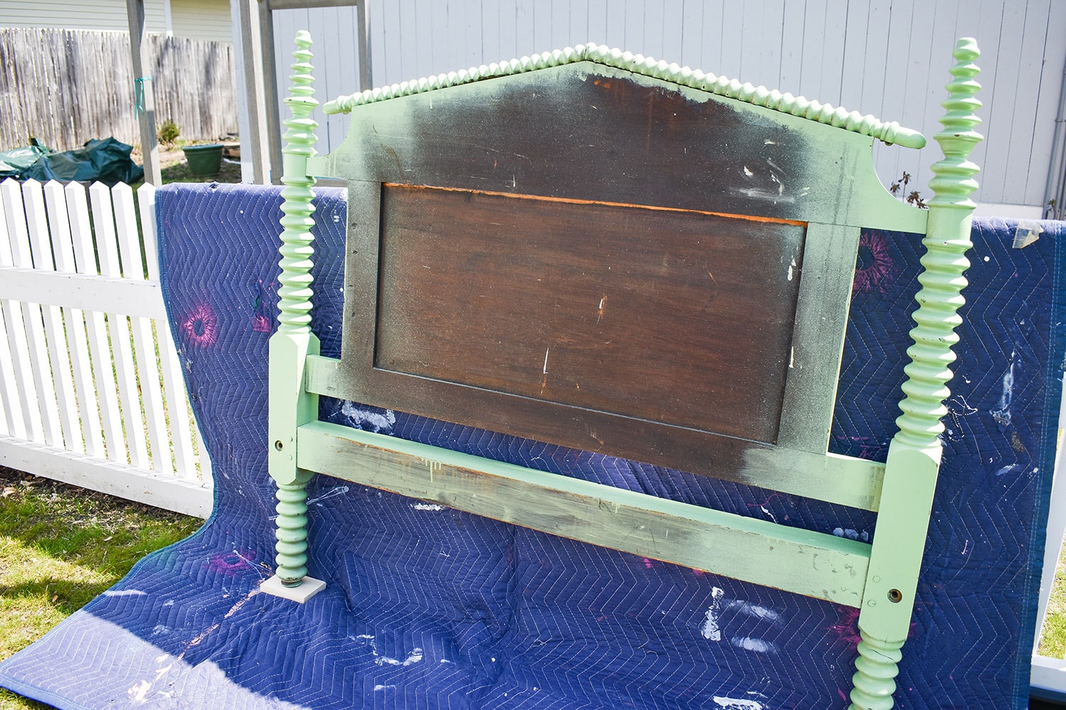 Wooden headboard with green paint on the perimeter. 