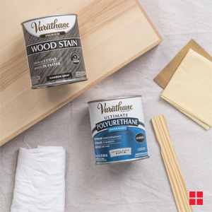 Pieces of bare wood and cans of Varathane wood stain and polyurethane.