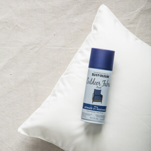 Can of Rust-Oleum Outdoor Fabric Paint with white throw pillow
