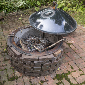 Dirty brick patio with rusted fire pit 