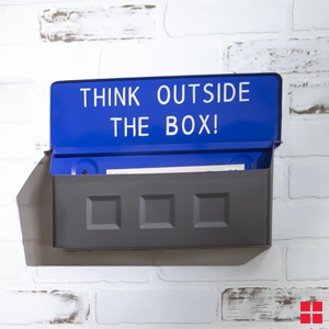 Wall mounted mailbox with “think outside the box” painted inside the cover.
