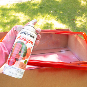 Can of Rust-Oleum Imagine spray paint in front of red painted frame.