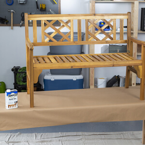 Wood bench on top of a table after being rubbed with Watco Teak Oil.