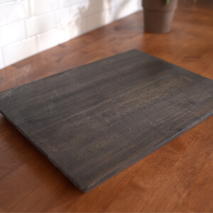 Dark brown wood charcuterie board with nothing on it.