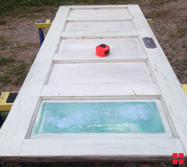 Old white door laying on saw horses.