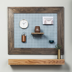 Finished Peg Board With Clock And Shelf Hanging On Wall