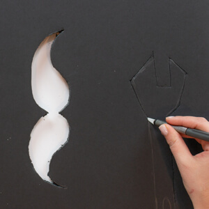 Hammer, mustache and wrench cut from foam board. 