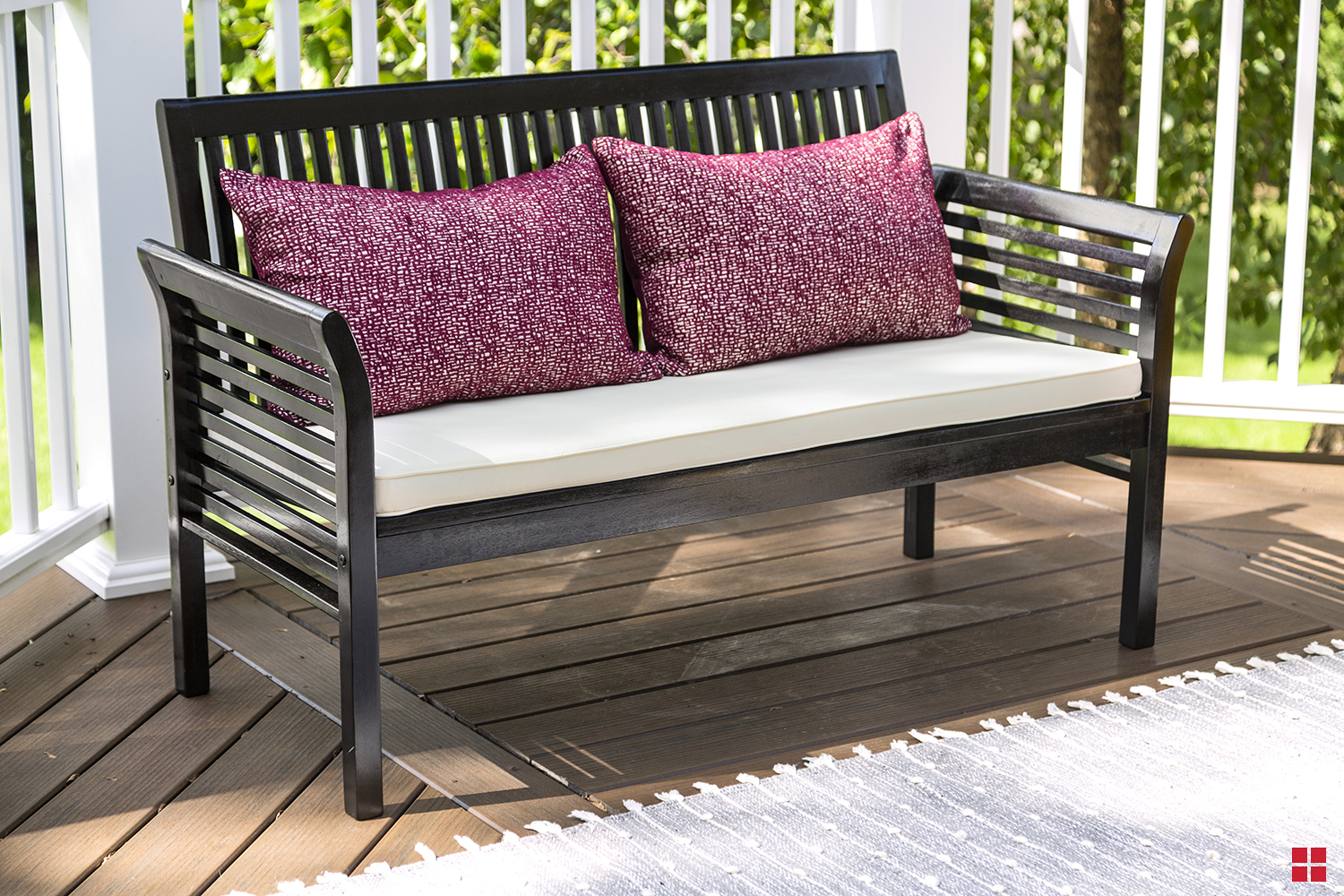 Painted wooden bench with two pillows and a seat cushion.