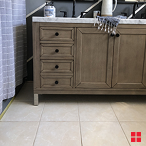 Wood vanity on a beige bathroom tile floor.