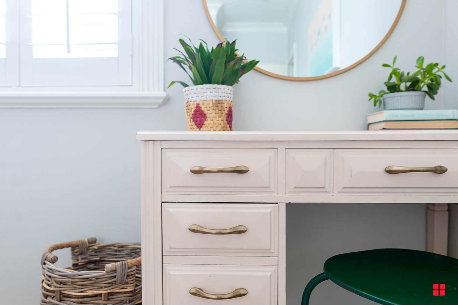 Pale pink desk with a green chair. 