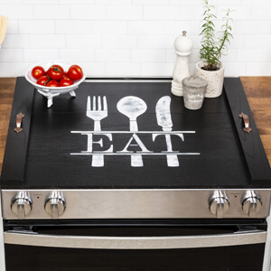 Black noodle board with the word “eat” painted on it.