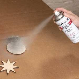 : Applying Rust-Oleum Stops Rust Bright Coat Metallic Finish spray paint to wood pieces.