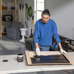 Woman using a rag to apply Varathane wood stain to bare wood.