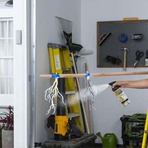 Woman spraying black paint on branches.
