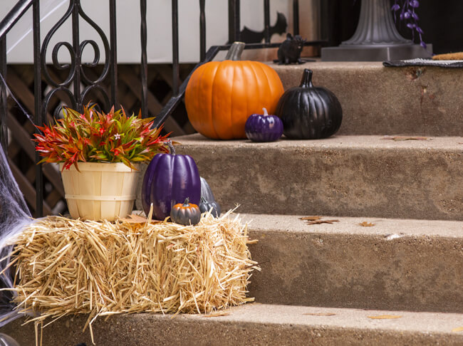 Painted pumpkins arranged on porch steps.