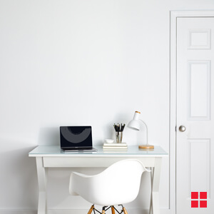 A white desk against a white wall.