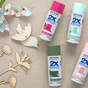 Unpainted wood birds and flower cut-outs and five cans of Rust-Oleum 2X Ultra Cover Spray Paint. 