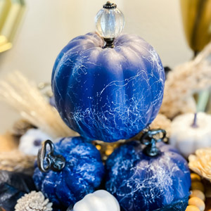 Small faux pumpkins painted royal blue with a white marble effect. 