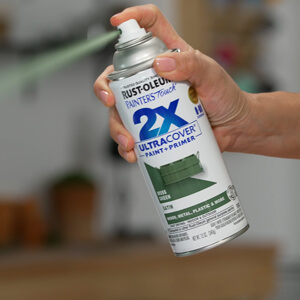 Hand holding a can of Rust-Oleum Spray Paint.