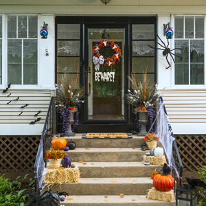 Halloween wreath and other decorations on home’s front porch.