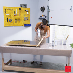 Using A Blow Dryer To Pop Air Bubbles And Wood Stir Stick To Guide Activated Mixture To Edge Of Shelf