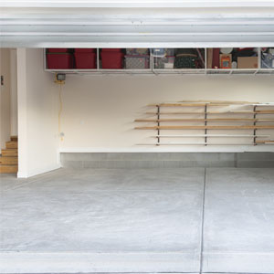 An empty garage with a gray, uncoated concrete floor.