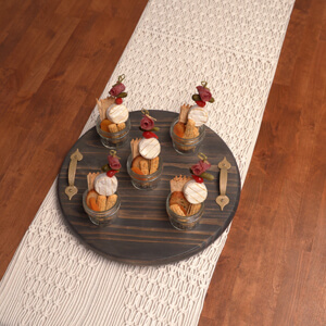 Stained wooden serving tray with charcuterie jars on it.