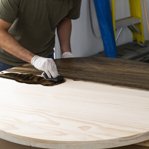 Man applying wood stain with cloth 