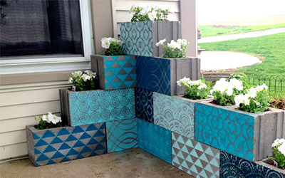 Painted cinderblock planters arranged on a patio.