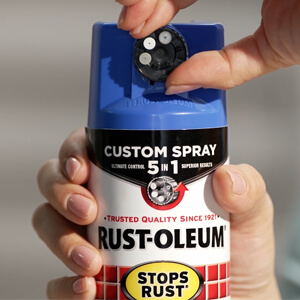 Hand holding a can of Rust-Oleum Stops Rust Custom Spray 5-in-1 spray.