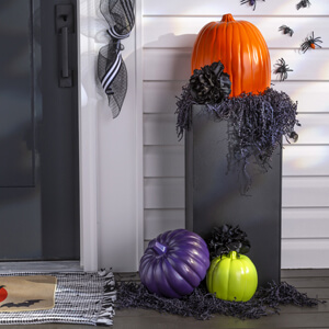 Porch with plastic pumpkins painted orange, purple and green. 