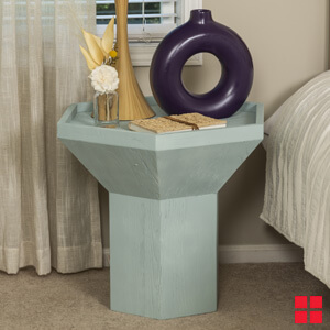 Light blue wood night stand next to a bed. 