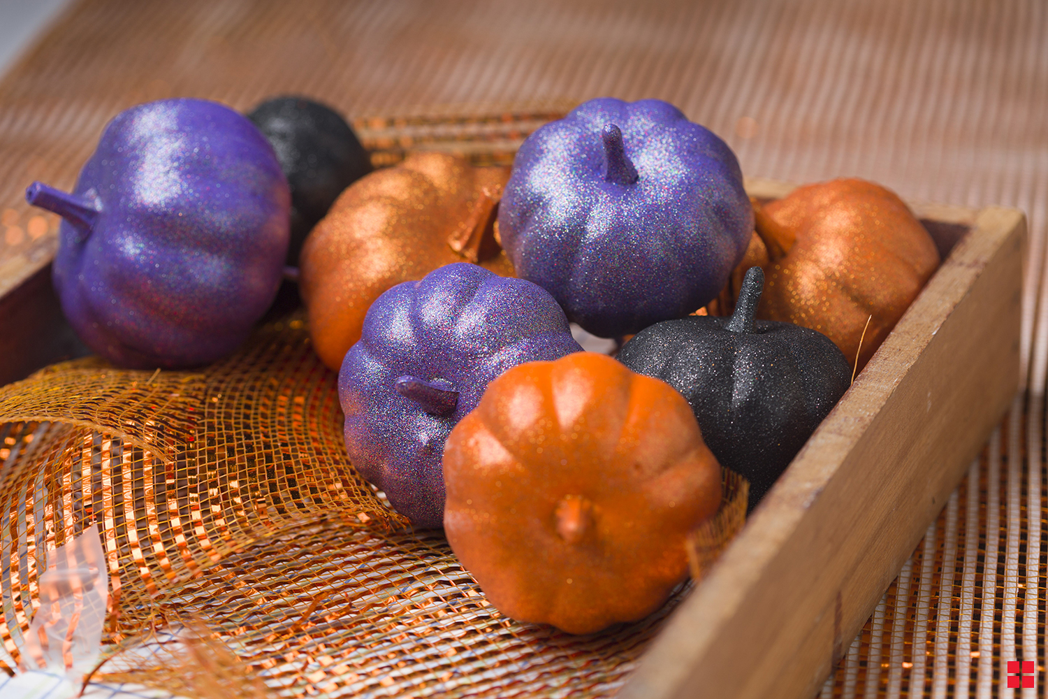 Small decorative pumpkins in glittery purple, orange and black. 