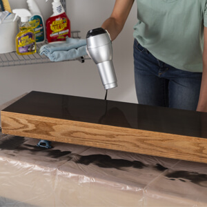 Using A Blow Dryer To Pop Air Bubbles And Wood Stir Stick To Guide Activated Mixture  To Edge Of Shelf