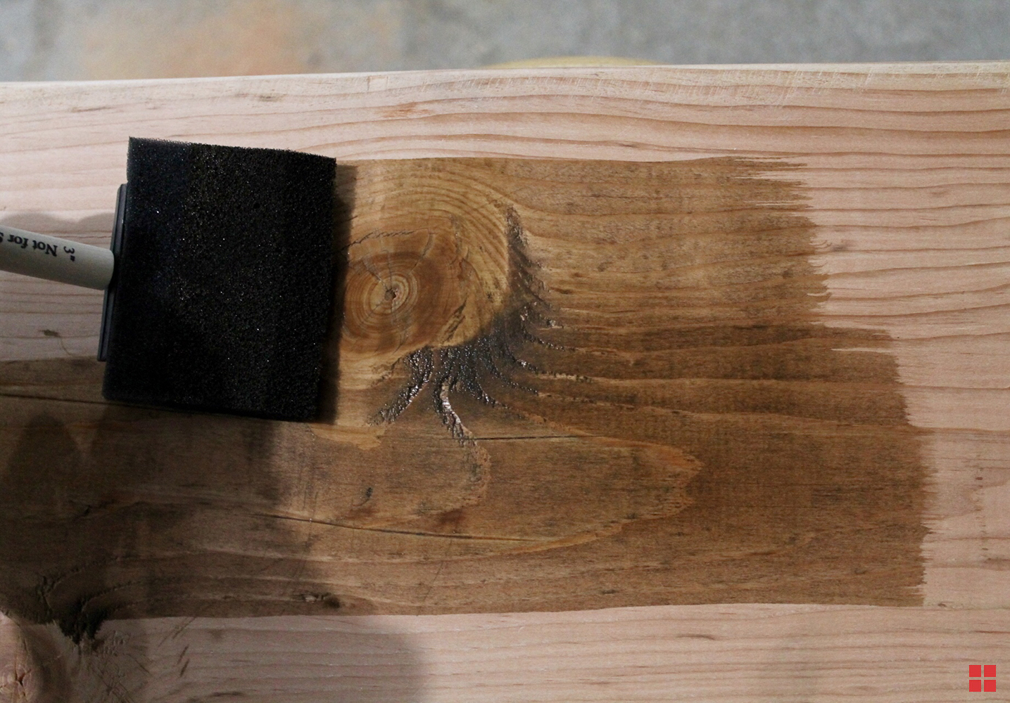 Using a foam brush to apply wood stain. 
