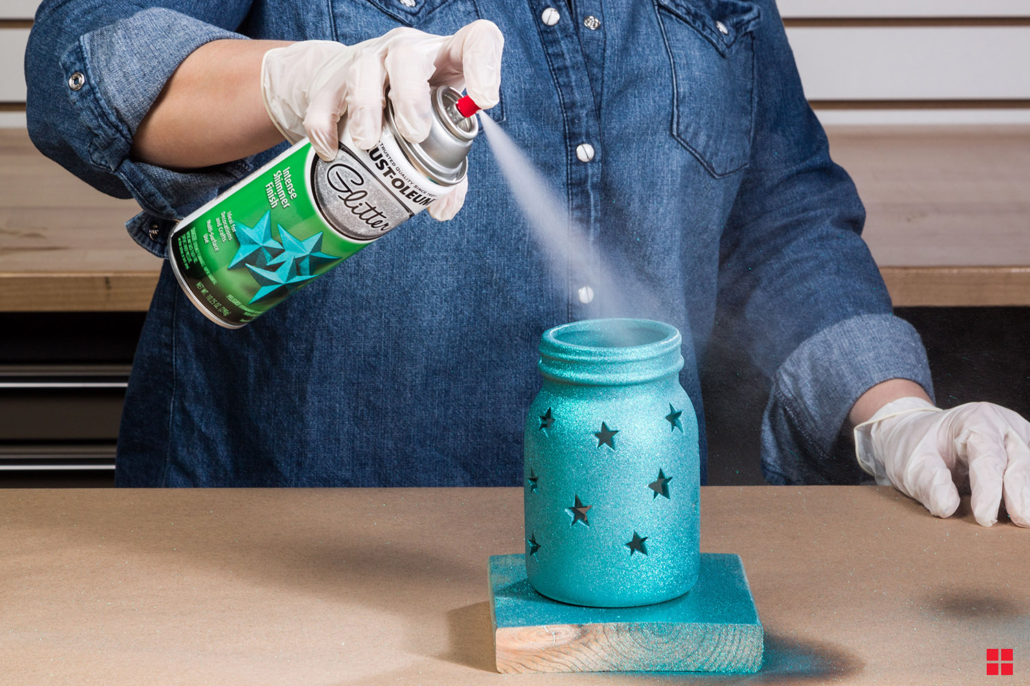 Rust-Oleum Glitter Spray Paint being sprayed on a star jar